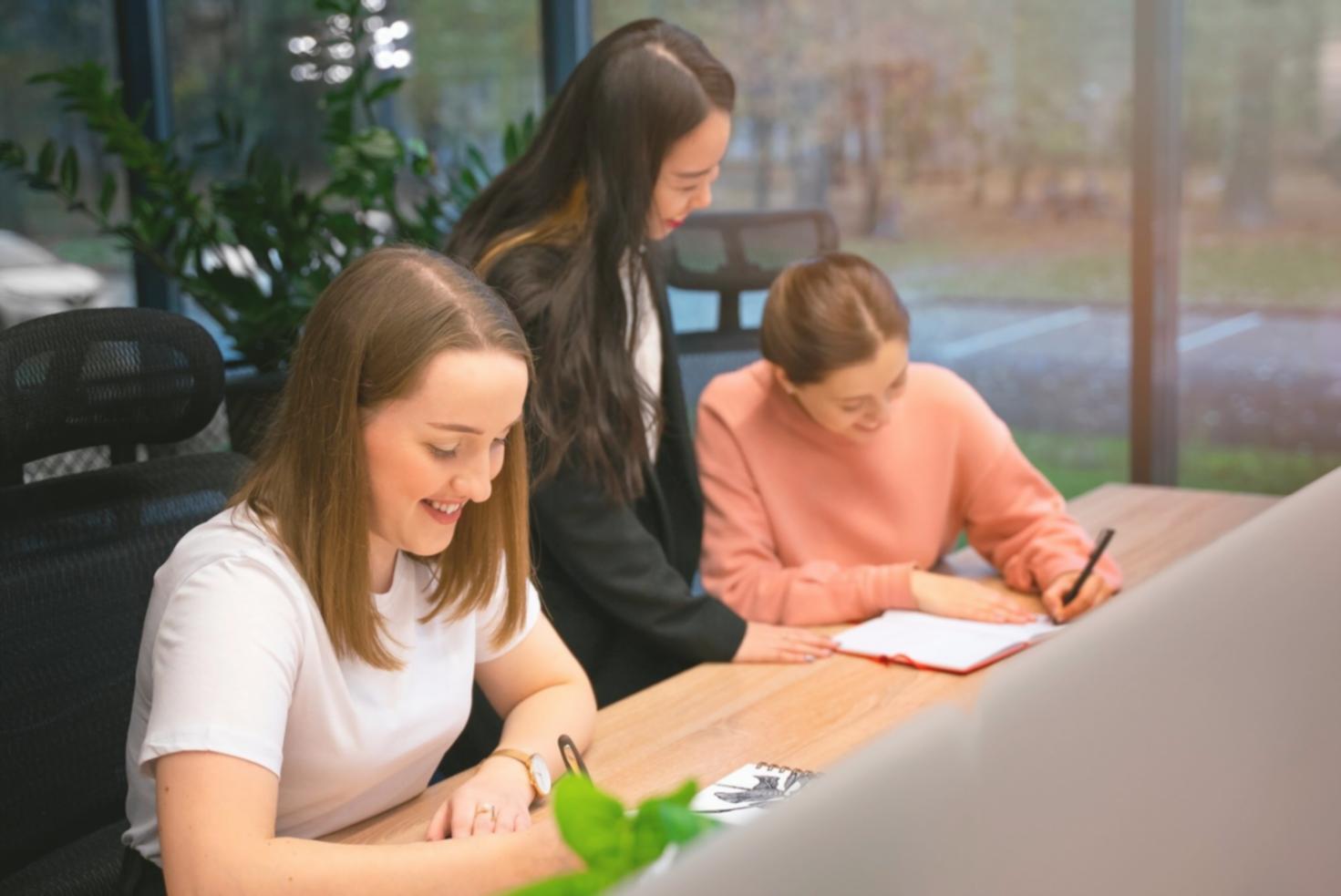 Gruppe von Teilnehmern bei der gemeinsamen Arbeit an Finanzmodellen in modernem Seminarraum